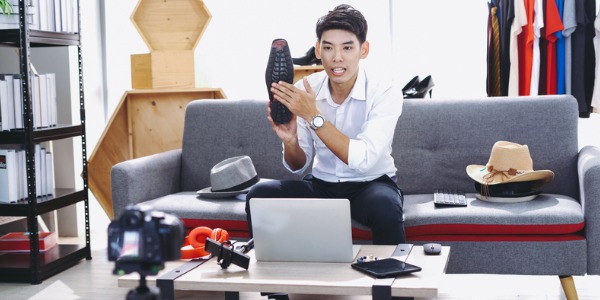 An influencer creating a vlog on fashionable dress shoes.