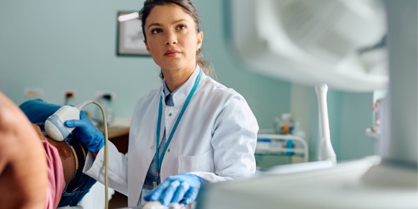 A diagnostic medical sonographer using special imaging equipment that directs sound waves into a patient’s body.