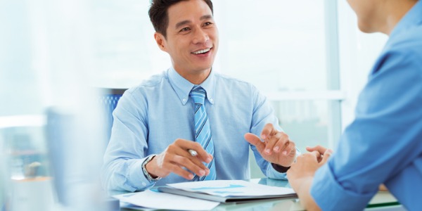 A human resources manager smiling and talking to an employee.