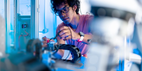 A robotics engineer working on a robotic arm.