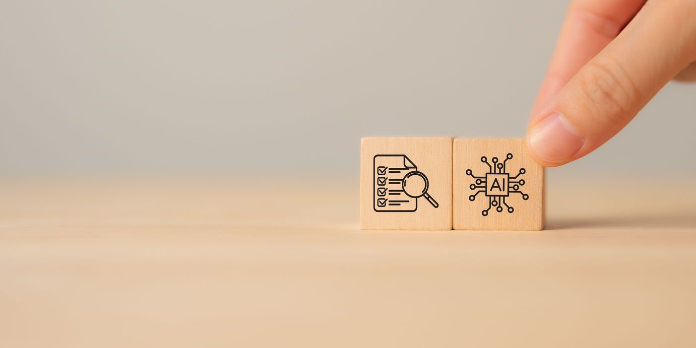 Two wooden blocks on a table depicting artificial intelligence and auditing.